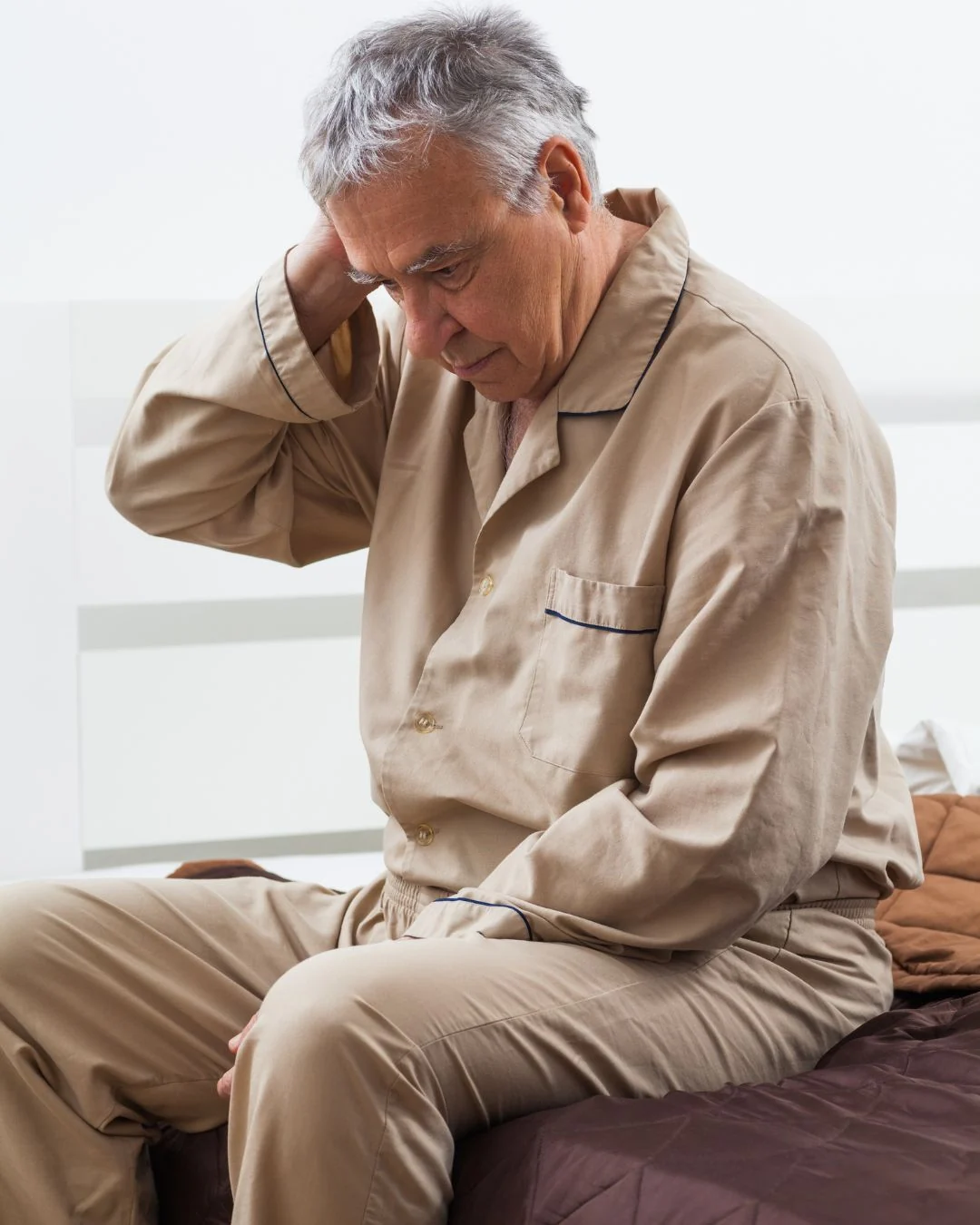 Older man sitting on the edge of the bed at night, the kind of restless evening people describe when blood sugar feels unsteady